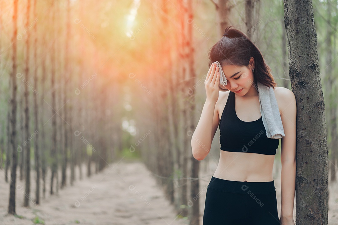 Mulher asiática exausta ou cansada após o treino na natureza