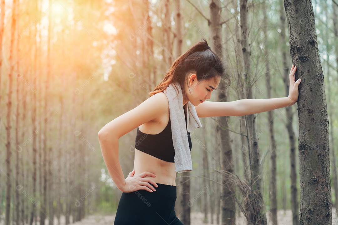 Mulher asiática exausta ou cansada após o treino na natureza