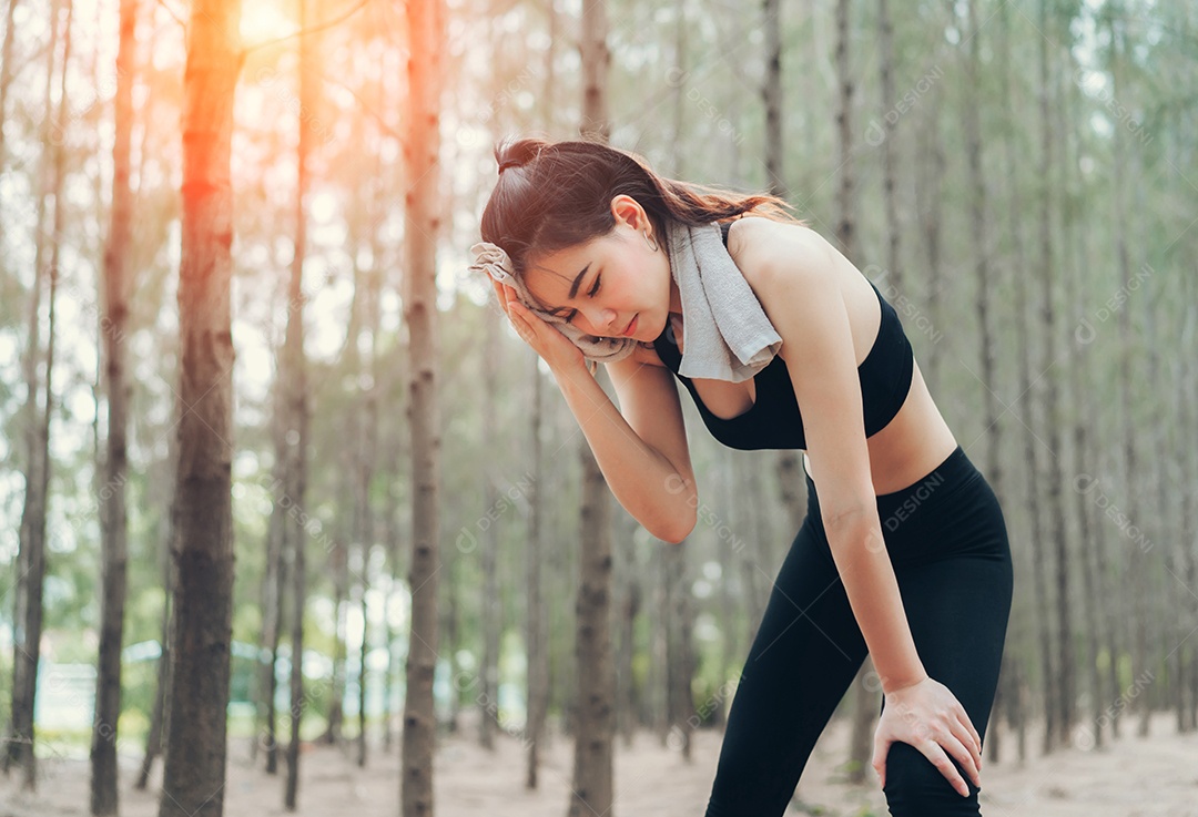 Mulher asiática exausta ou cansada após o treino na natureza
