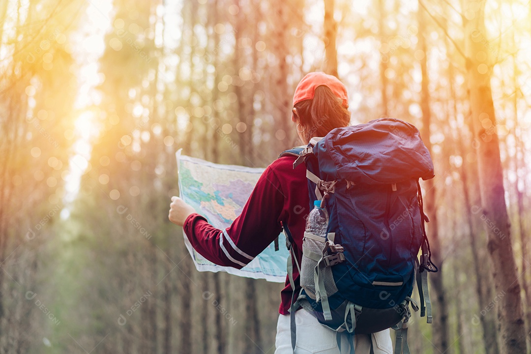 A mulher asiática viaja com a mochila na floresta