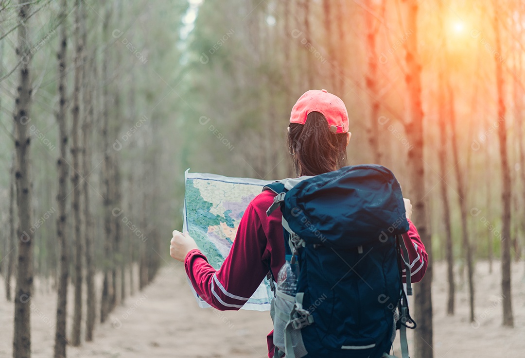 A mulher asiática viaja com a mochila na floresta