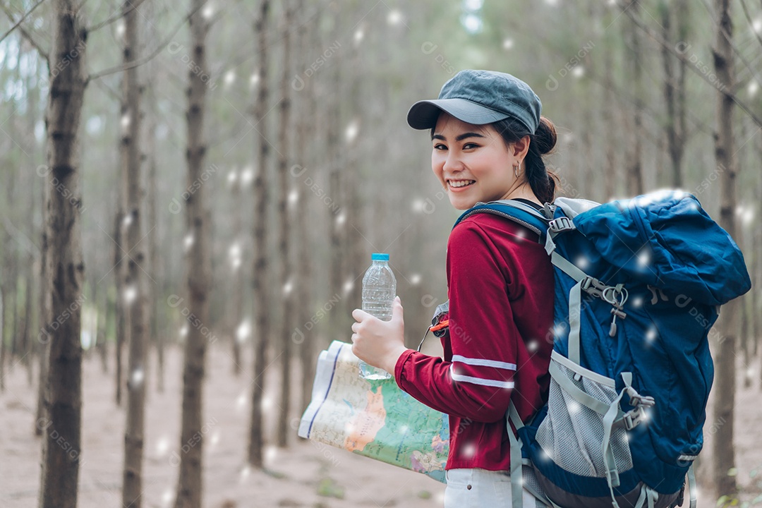 A mulher asiática viaja com a mochila na floresta