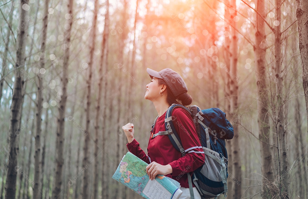 A mulher asiática viaja com a mochila na floresta