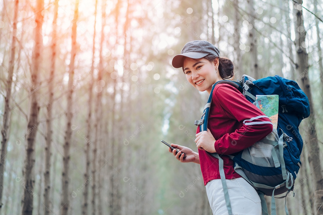 A mulher asiática viaja com a mochila na floresta