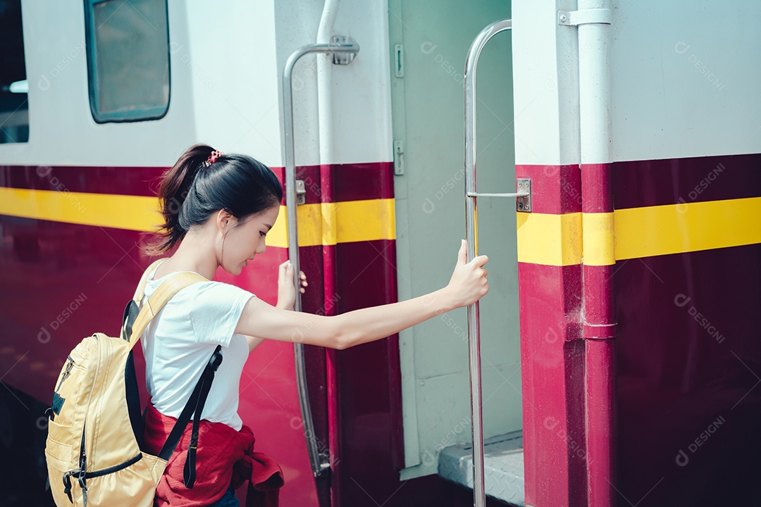 Jovem turista asiática pega o trem com mochila