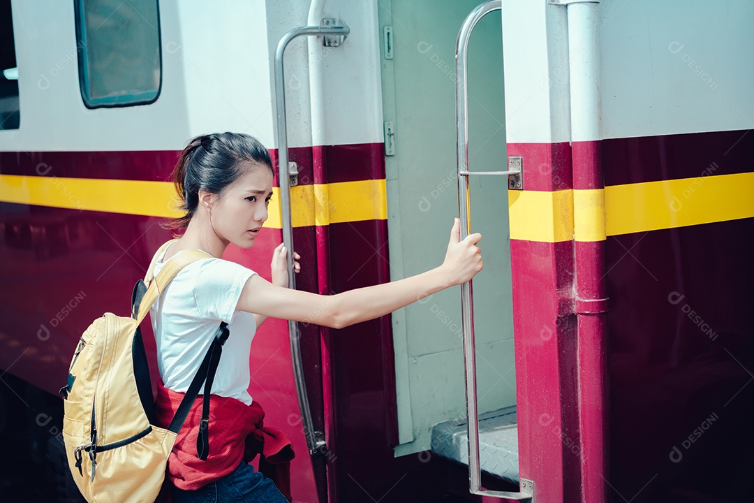 Jovem turista asiática pega o trem com mochila