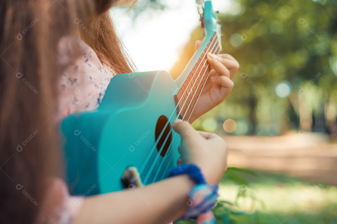 Mulher jovem segurando ukulele em floresta