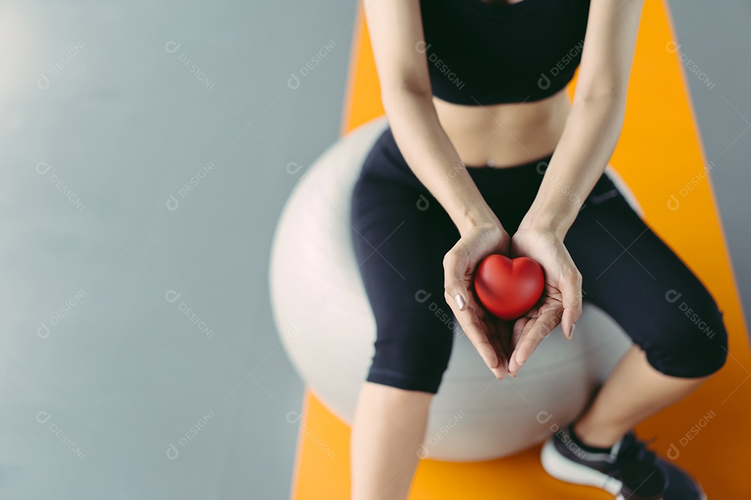 Exercício de treino de mulher segurando coração vermelho no estilo de vida saudável