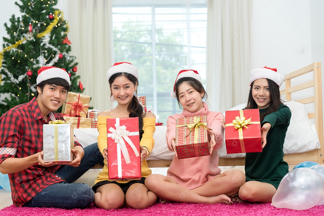 Jovem grupo asiático homem e mulheres juntos segurando caixa de presente