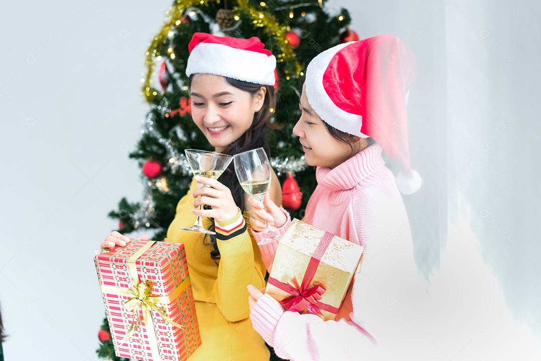 Menina asiática segurando caixa de presente em fundo de árvore de natal