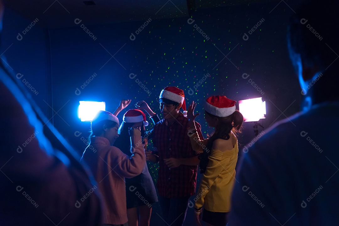 Homens e mulheres jovens do grupo asiático dançando a festa de natal