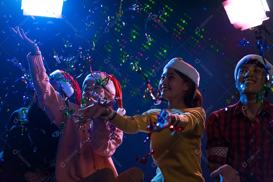 Homens e mulheres jovens do grupo asiático dançando na festa de natal