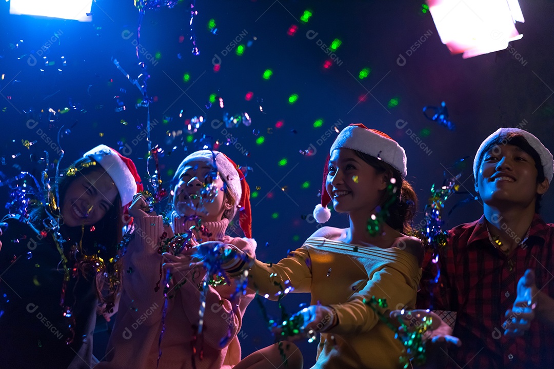 Homens e mulheres jovens do grupo asiático dançando na festa de natal