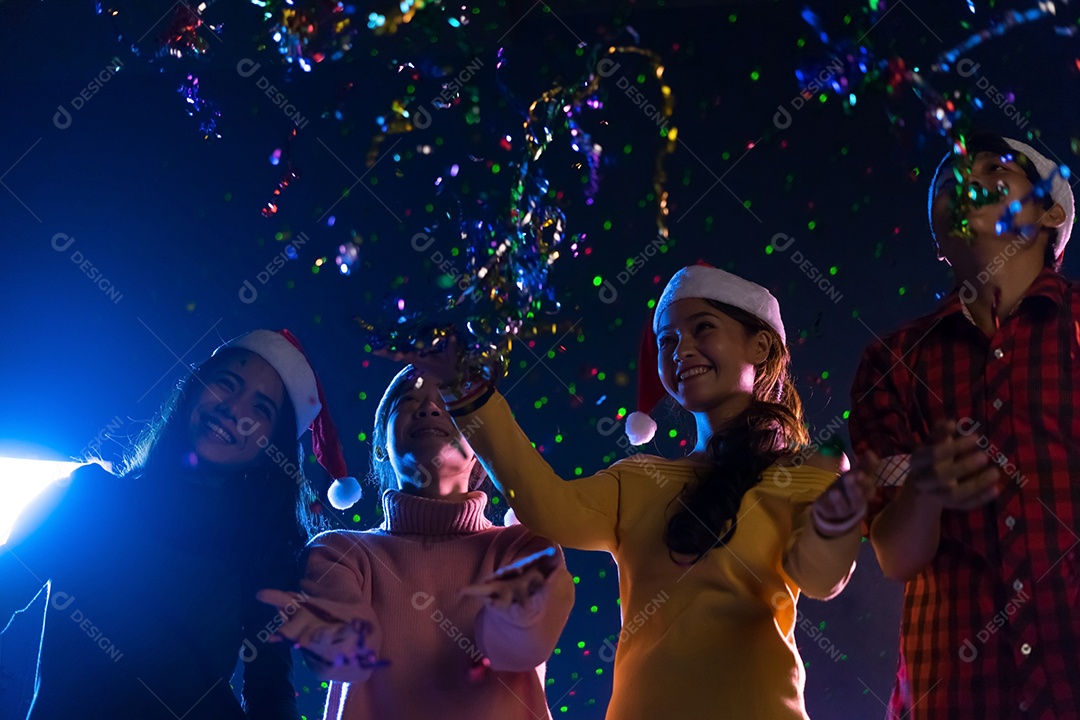 Homens e mulheres jovens do grupo asiático dançando na festa de natal