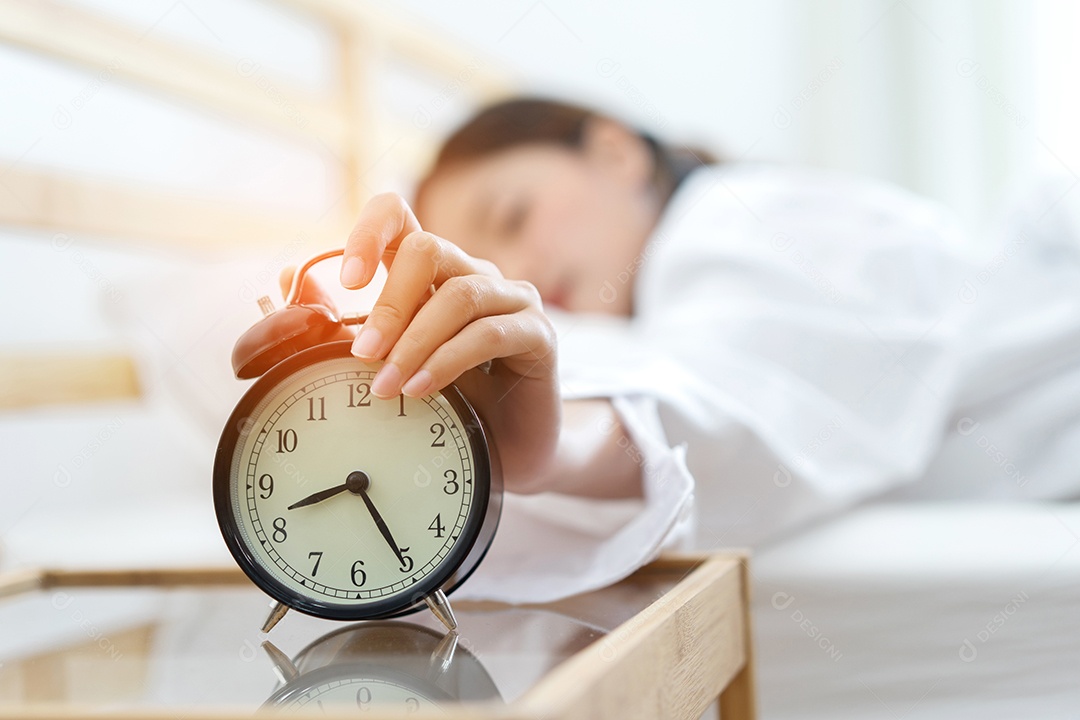 A mulher acorda no final da manhã olhando o despertador