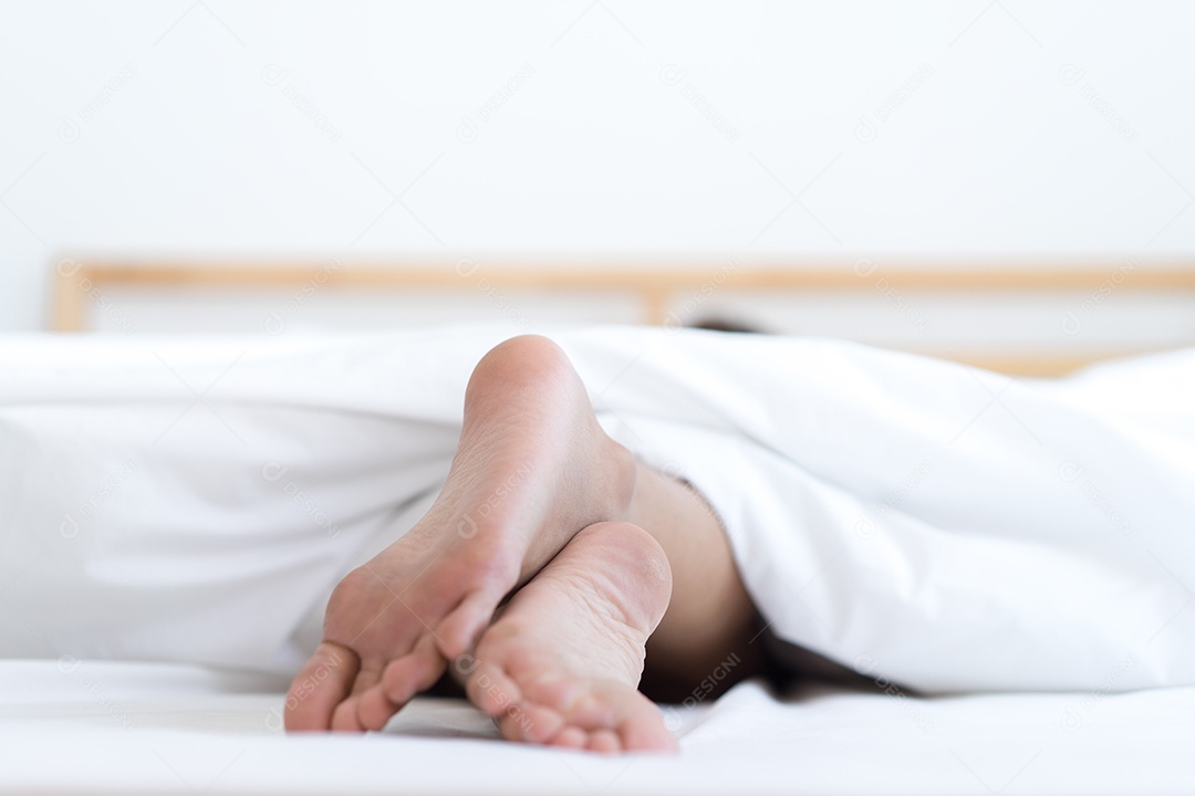 Pés mulher deitada relaxando na cama