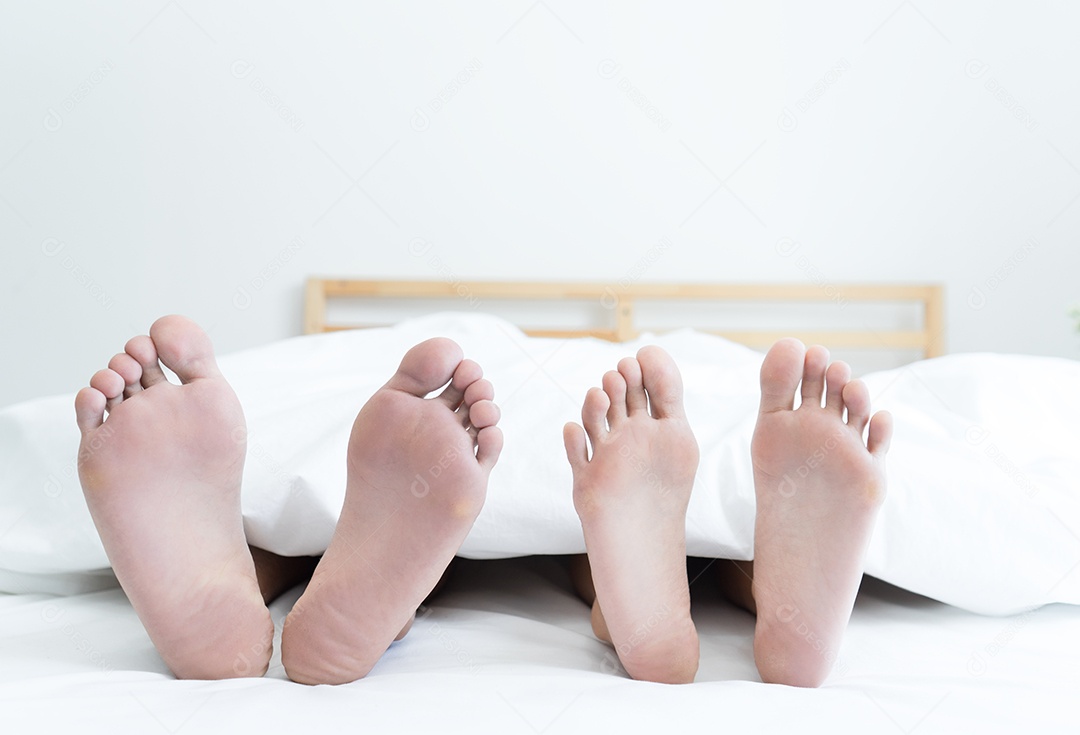 Pés mulher e homem casal deitados na cama relaxando