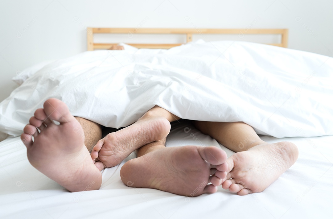 Pés mulher e homem casal deitados na cama relaxando