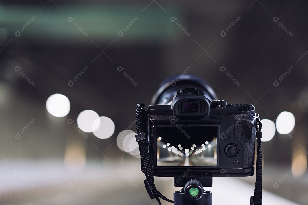 Câmera no tripé tira fotos no túnel do metrô com luz bokeh
