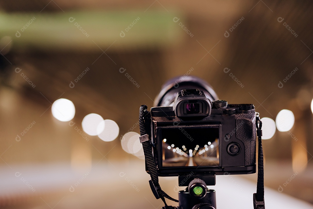 Câmera no tripé tira fotos no túnel do metrô com luz bokeh