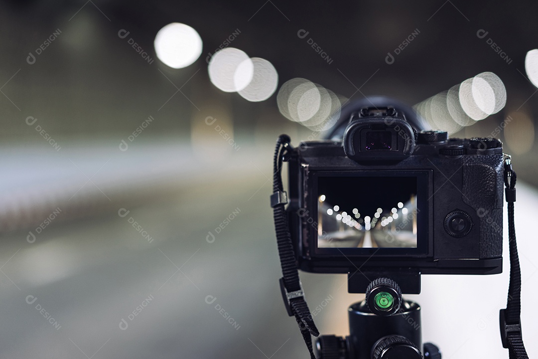 Câmera no tripé tira fotos no túnel do metrô com luz bokeh