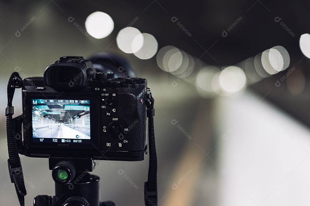 Câmera no tripé tira fotos no túnel do metrô com luz bokeh