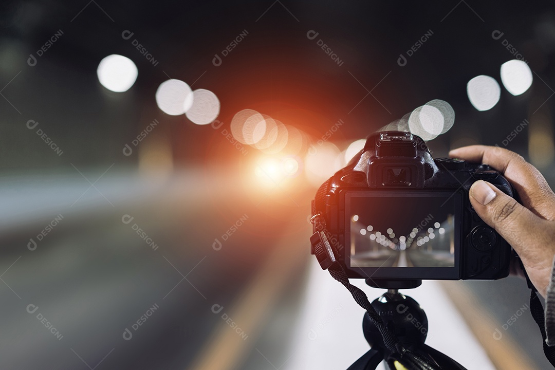 Câmera no tripé tira fotos no túnel do metrô com luz bokeh