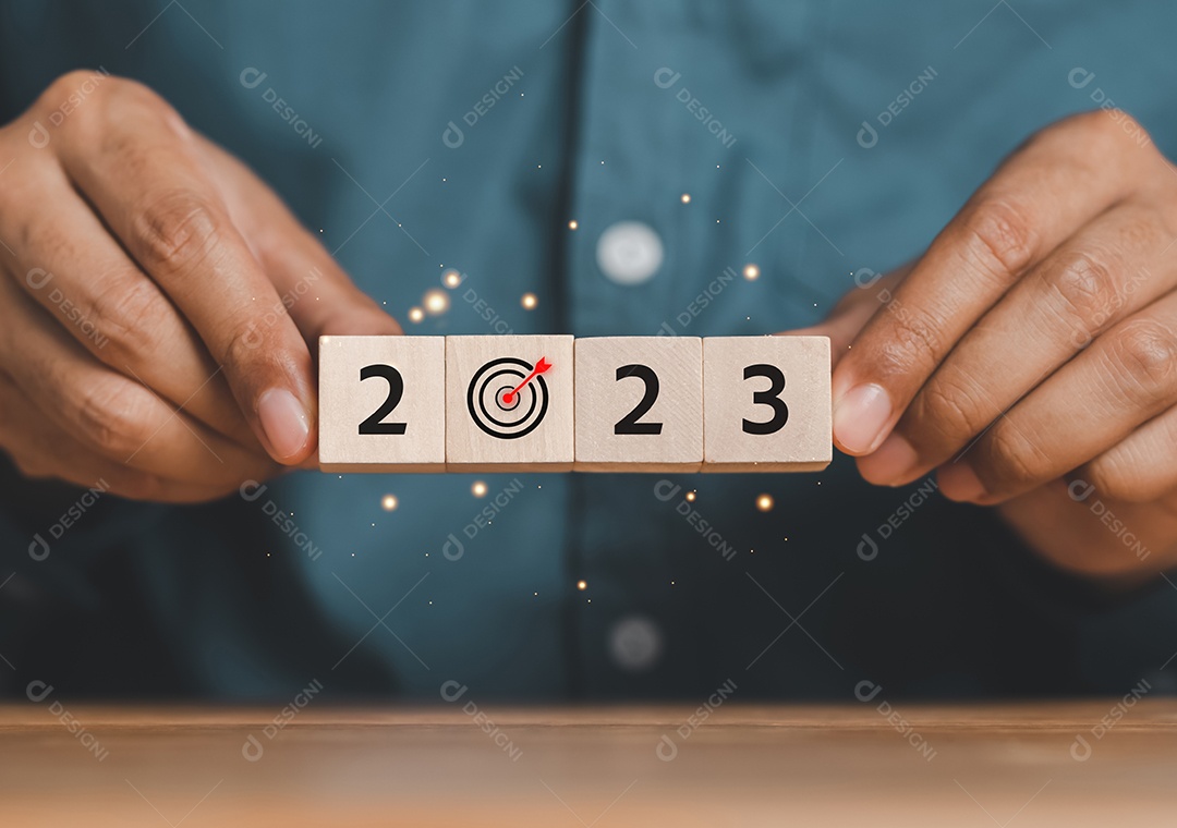 Empresário segura bloco de cubo de madeira com mudança de contagem regressiva de 2023