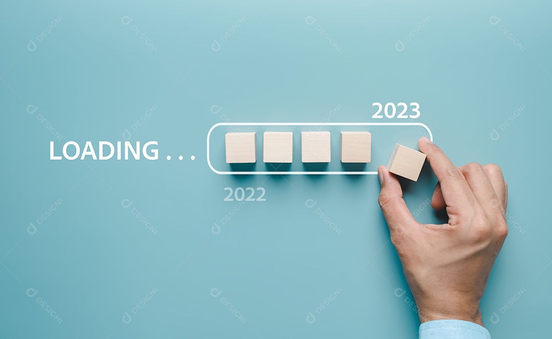 Mão colocando bloco de cubo de madeira para carregar o progresso de 2022 a 2023