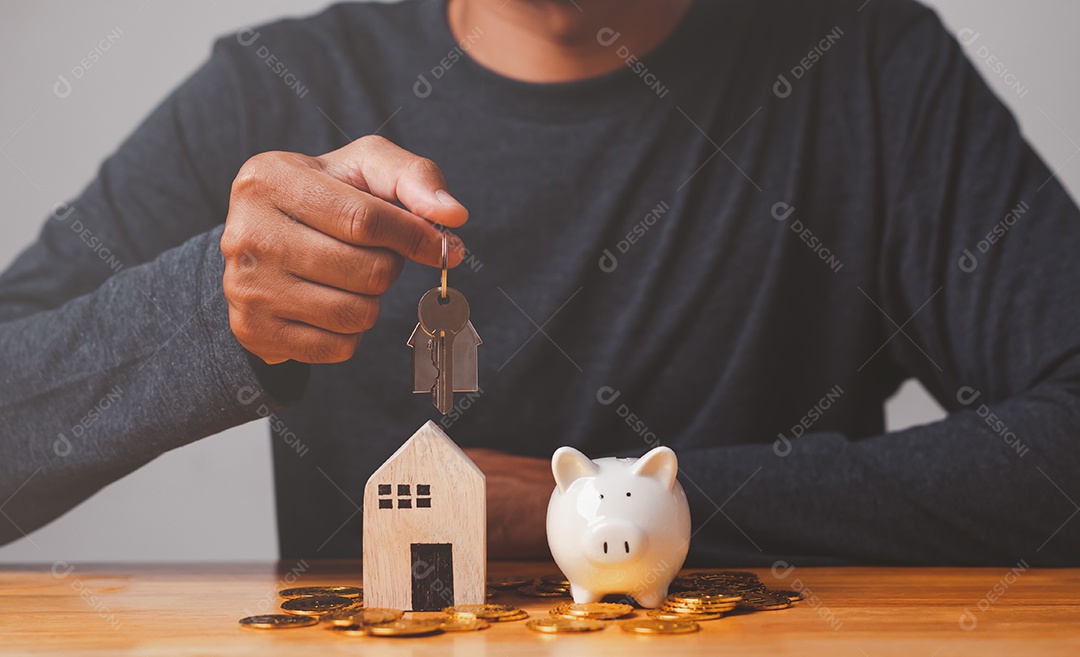 Empresário com moeda, cofrinho, segure a chave e a casa na mesa, doação, economia