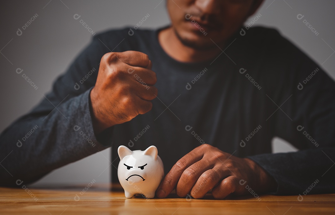 O homem da crise quebra seu cofrinho em uma mesa.