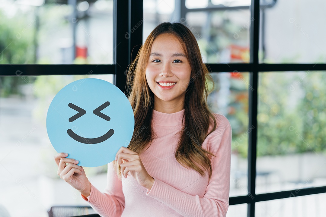 Mulher asiática segurando sorriso feliz azul no corte de papel, usuário dando boa classificação de feedback