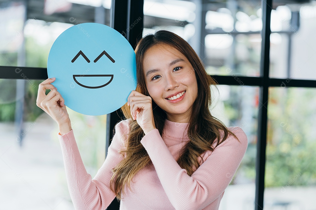 Mulher asiática segurando sorriso feliz azul no corte de papel, usuário dando boa classificação de feedback