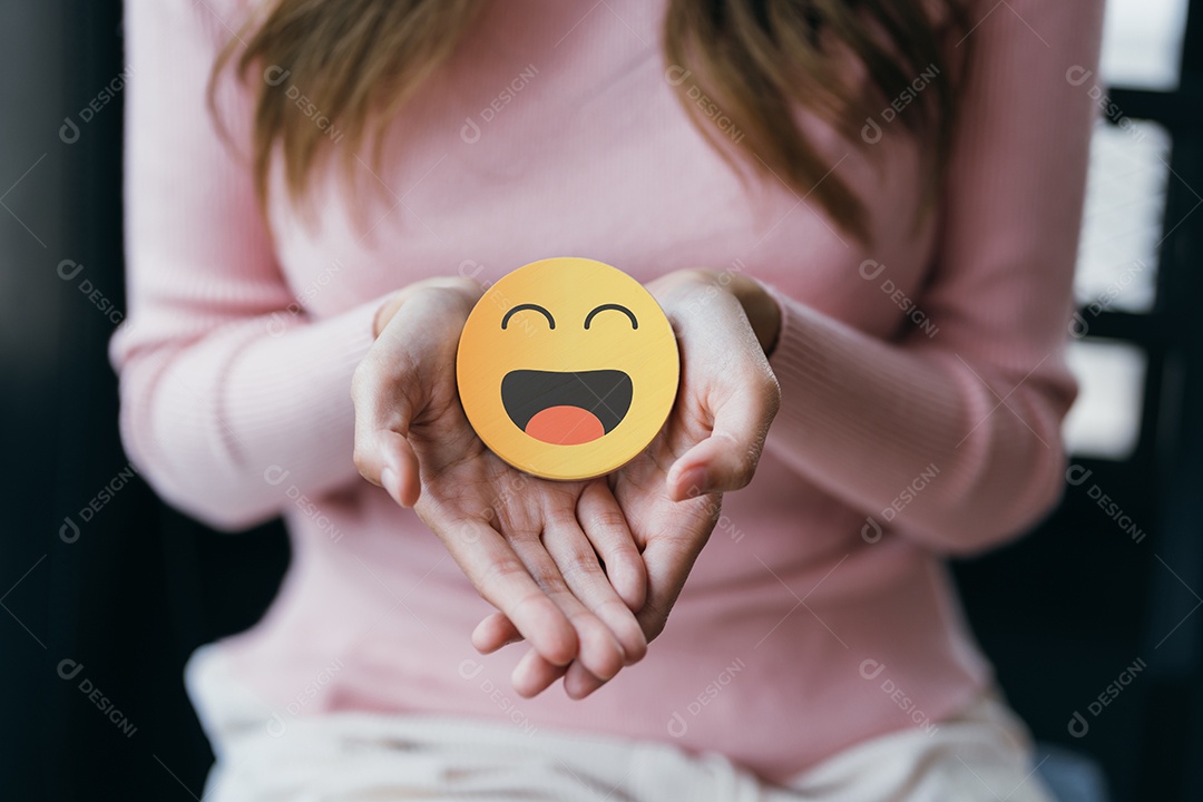 Mãos de mulher segurando sorriso feliz no bloco de madeira, usuário dando boa classificação de feedback