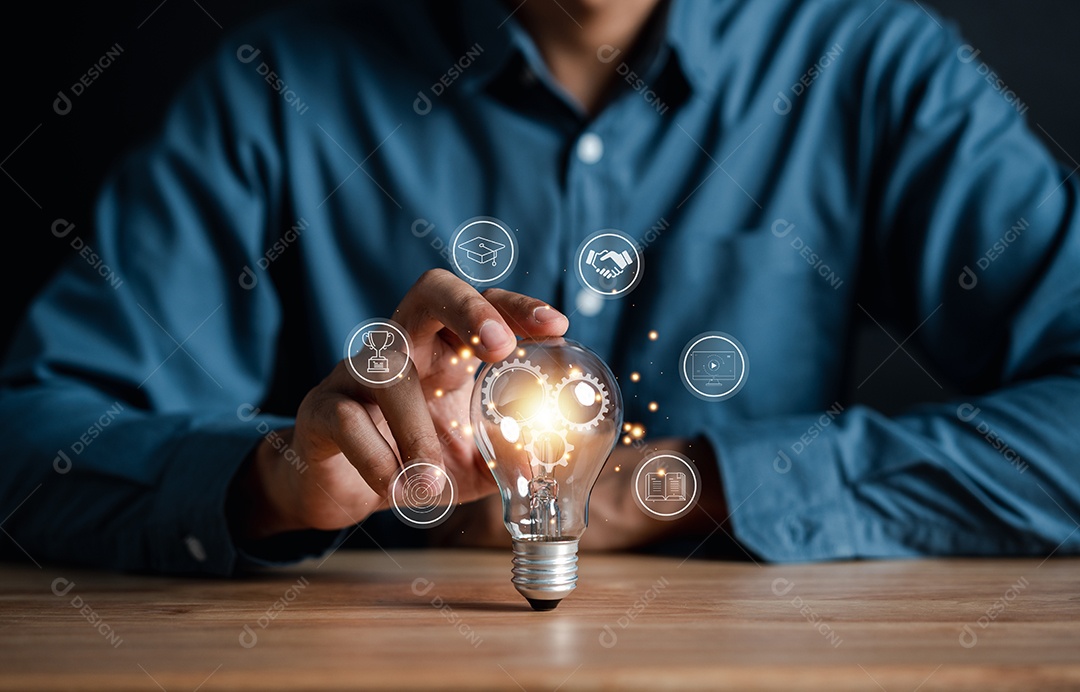 Mão de homem segurando lâmpada com aprendizagem educar e conceito de graduação.