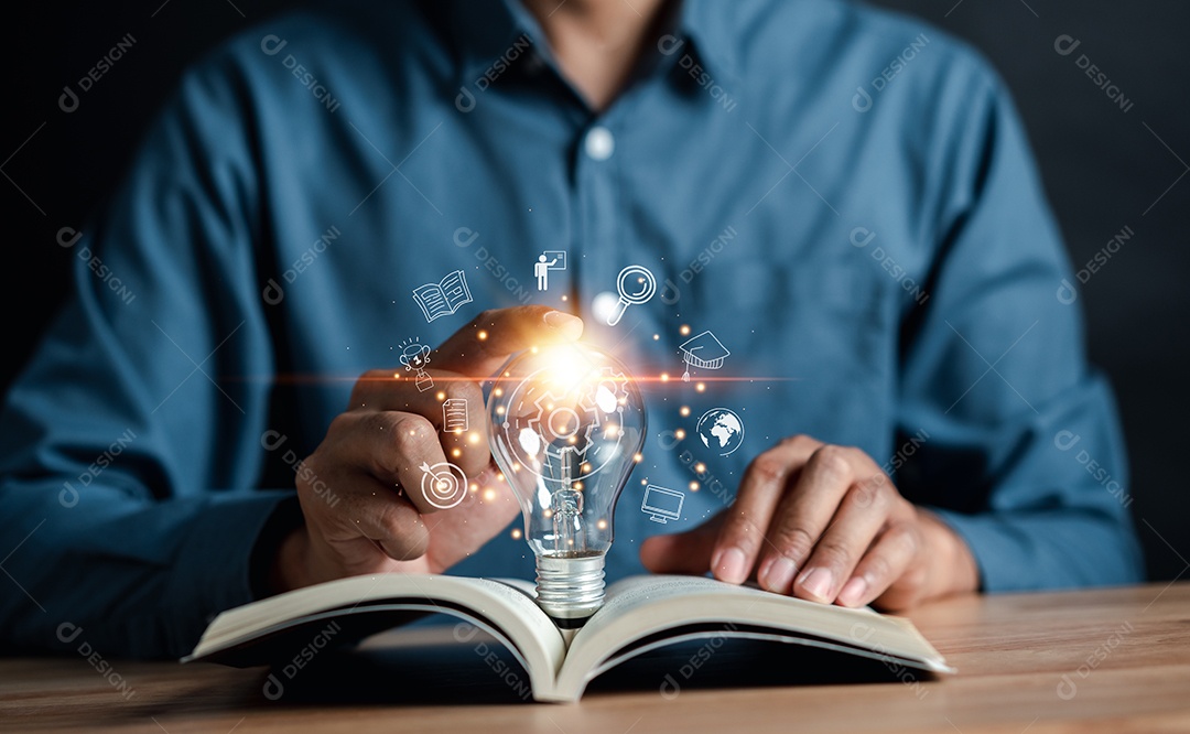 Mão de homem segurando lâmpada com livro de aprendizagem educar e conceito de graduação.