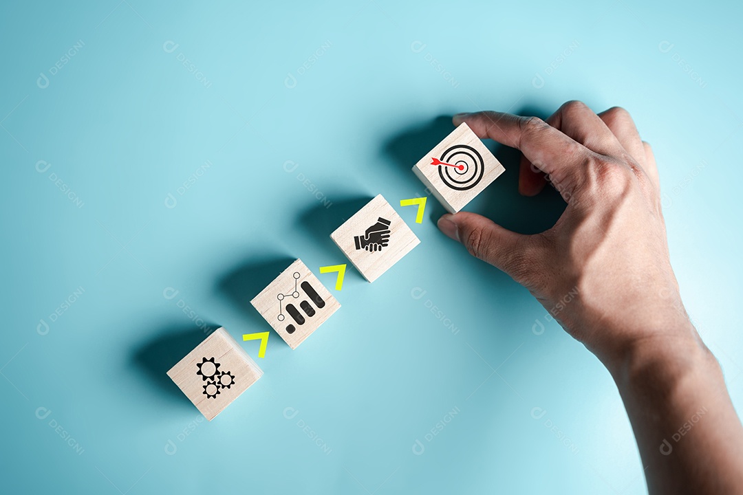 Passo para o sucesso da mão organiza um bloco de madeira com ícone de alvo de negócios.