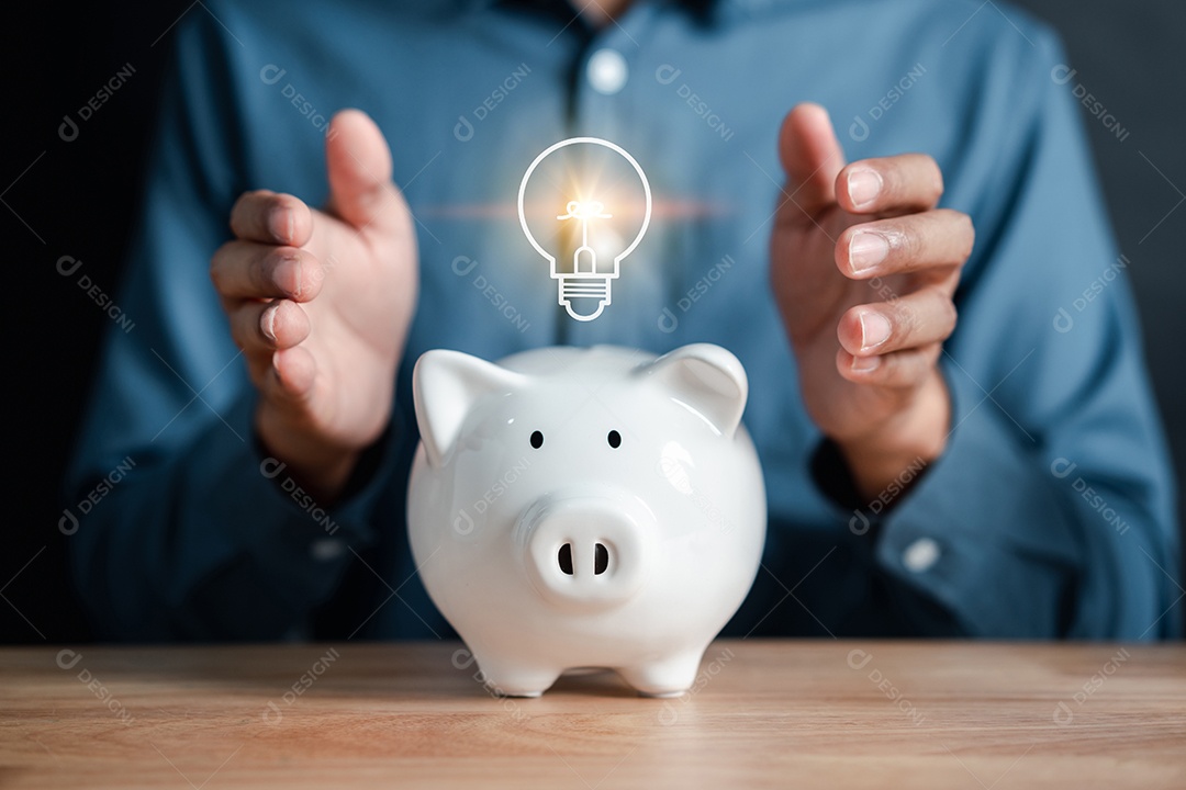 Empresário segurando a moeda no cofrinho com ícone de lâmpada.