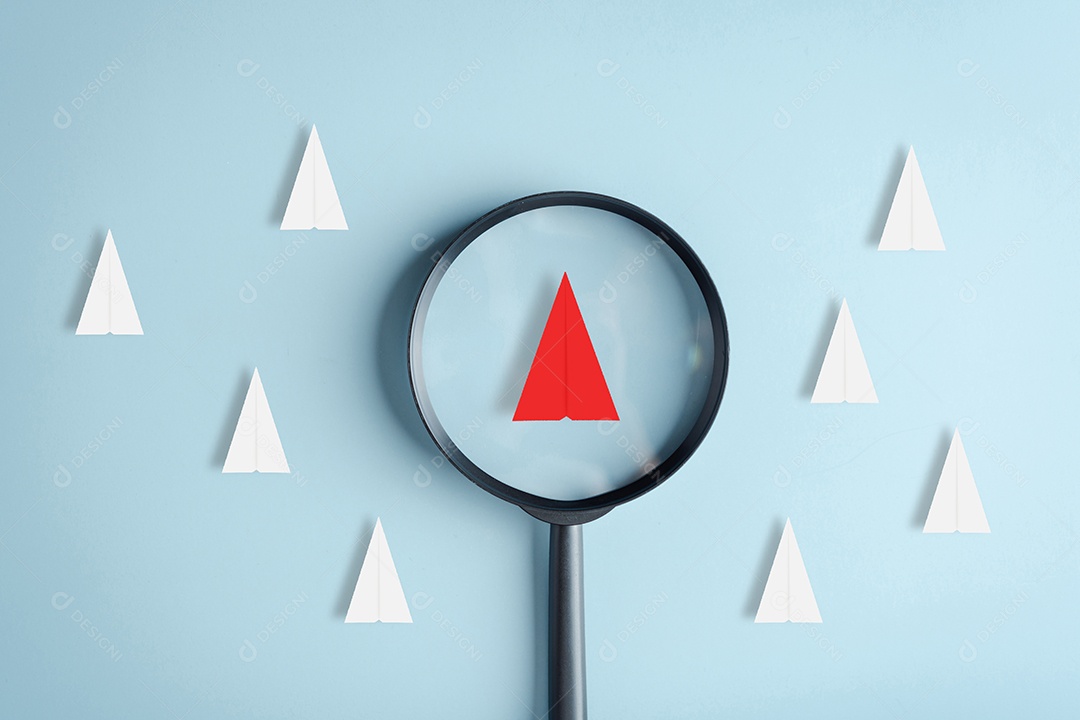 O foco da lupa é a liderança do avião de papel vermelho entre o avião de papel branco