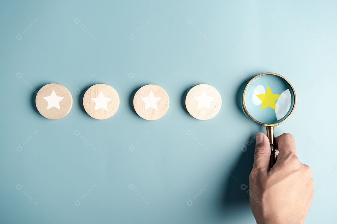Foco da lupa no ícone de cinco estrelas, conceito de revisão de feedback de satisfação do cliente.