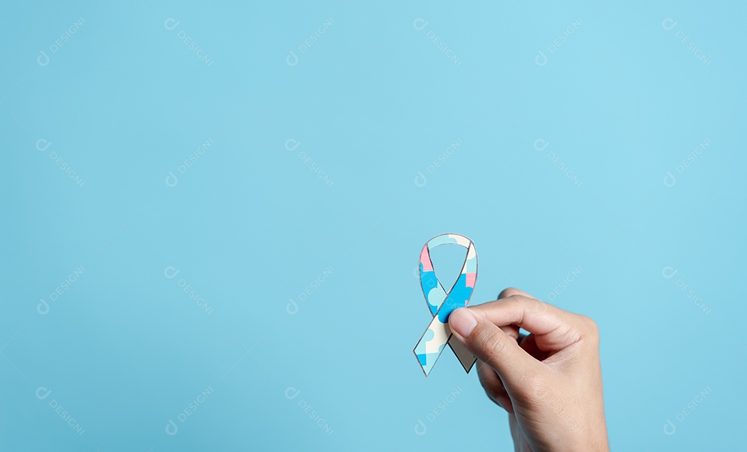 Mão segurando o quebra-cabeça da fita, símbolo de quebra-cabeça colorido de conscientização para o apoio à família do transtorno do espectro do autismo.