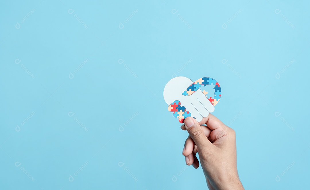 Papel de símbolo de quebra-cabeça de mão cortado de conscientização para apoio à família de transtorno do espectro do autismo.