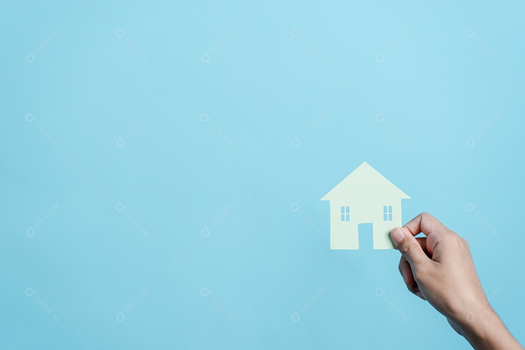 Mão segurando o corte de papel da casa, casa da família, habitação sem-teto, crise hipotecária e seguro de proteção residencial
