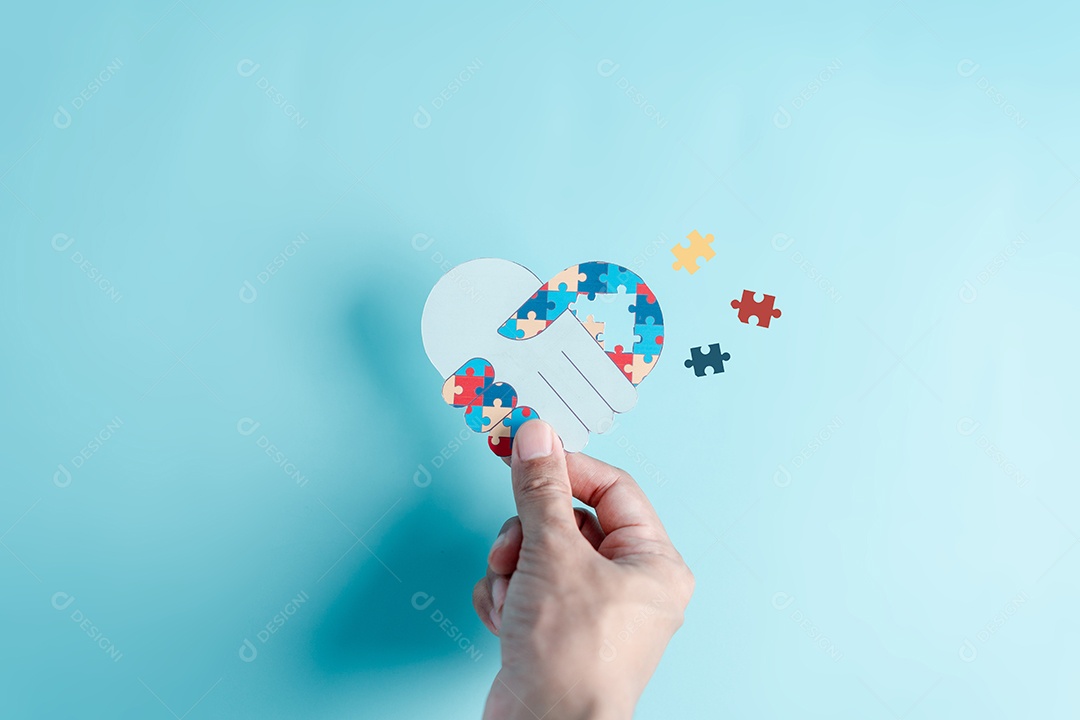 Papel de símbolo de quebra-cabeça de mão cortado de conscientização para apoio à família de transtorno do espectro do autismo.