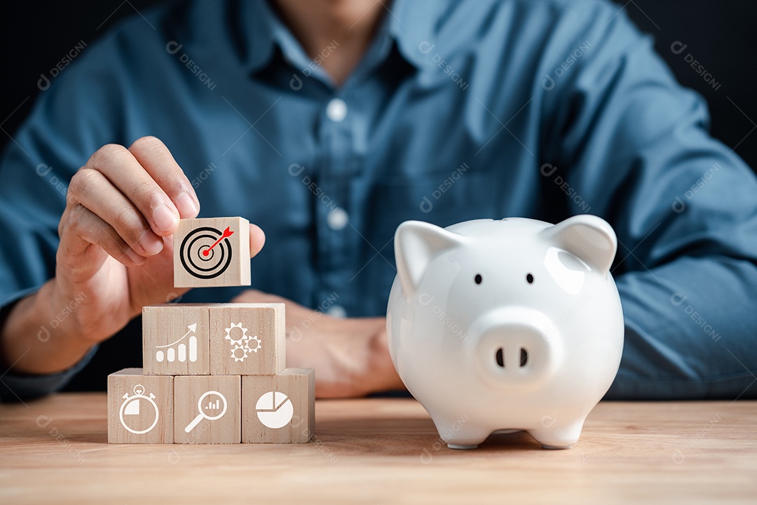 Empresário economizando dinheiro na realização do objetivo do cofrinho.