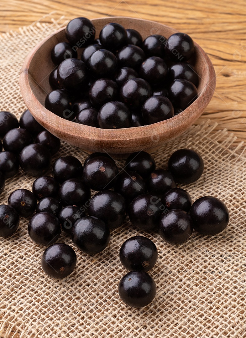 Jabuticabas em uma tigela sobre mesa de madeira.