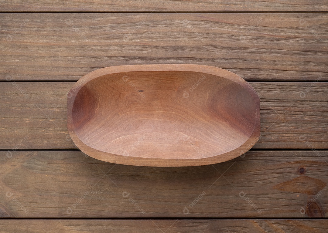Tigela de madeira artesanal vazia sobre a mesa de madeira.
