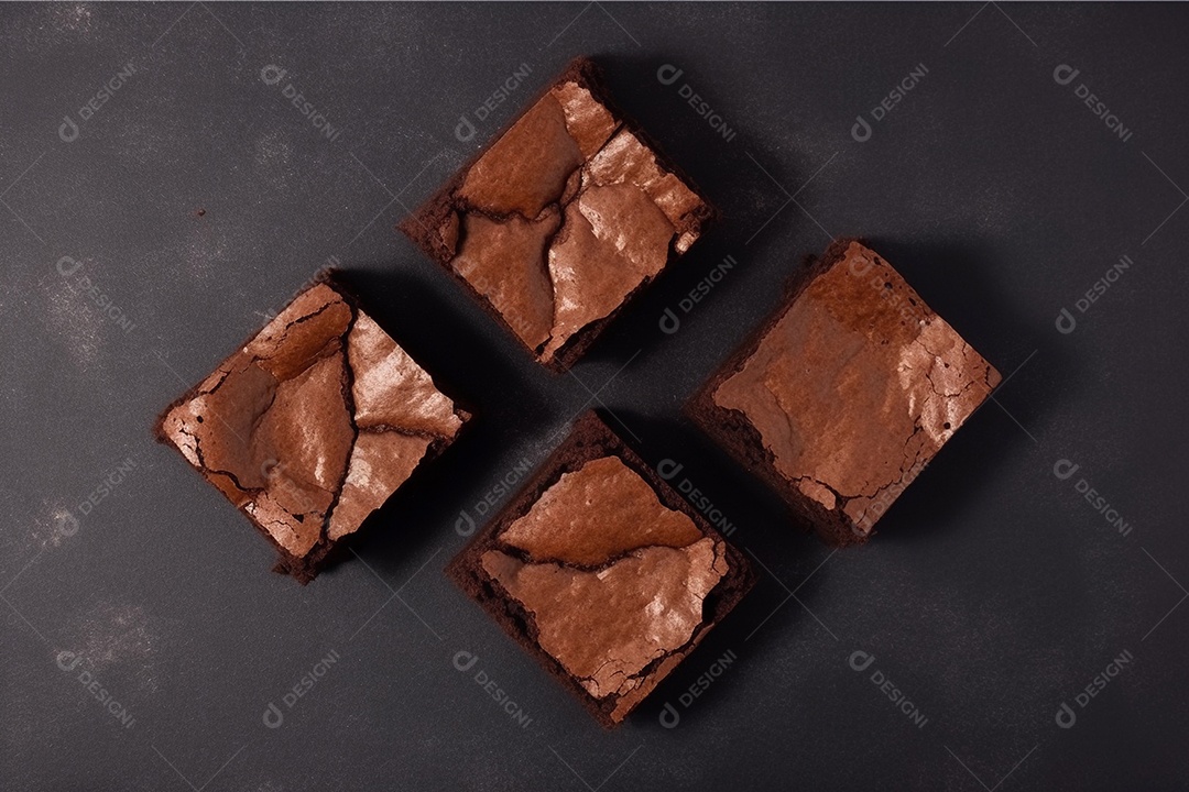 Pedaços quadrados de brownie cortam fatias sobre a mesa de madeira