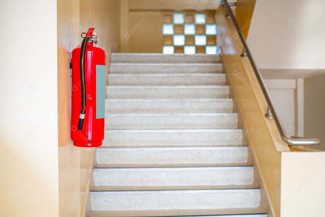 Um extintor de incêndio está pendurado na escada. Conceito de segurança contra incêndio.