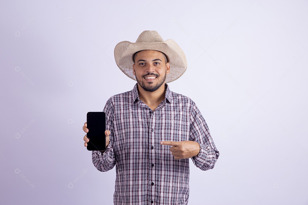 Homem jovem barbudo usando roupas de São João segurando celular smartphone